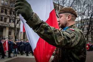 żołnierz obok flagi Polski