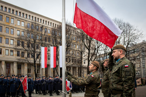 żołnierze oraz policjanci obok flag Polski