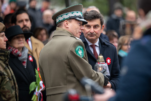 generał Straży Granicznej trzymający zapalony znicz