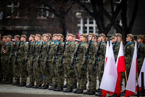 polscy żołnierze obok polskich flag