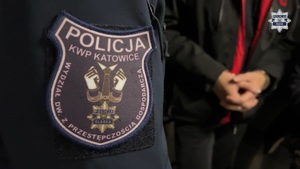 mundur z emblematem na tle osoby zatrzymanej