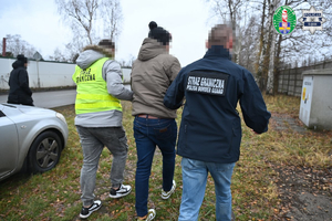 funkcjonariusze prowadzący kobietę