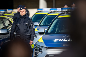 Policjanci na tle nowych radiowozów