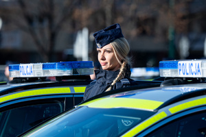 policjantka stojąca obok nowych radiowozów