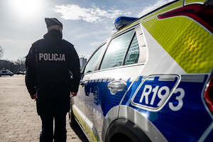 policjant stojący obok nowego radiowozu