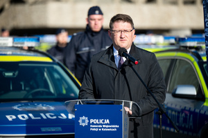 cywil przemawiający podczas uroczystości przekazania nowych radiowozów
