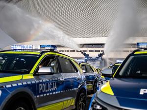 nowe radiowozy oraz pojazd z armatką wodną na tle katowickiego spodka