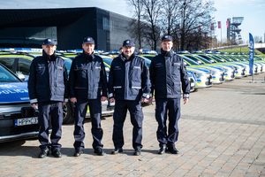 umundurowani policjanci na tle nowych radiowozów