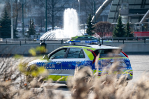 nowy radiowóz na tle tryskającej fontanny