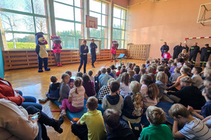 policjanci oraz osoby przebrane za maskotki w szkole podczas spotkania profilaktycznego z najmłodszymi