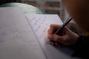 policjantka dokonuje pamiątkowego wpisu związanego z wizytą w placówce medycznej