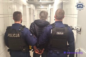 policjanci prowadzą zatrzymanego