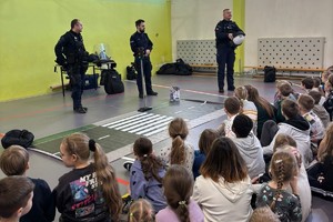 na zdjęciu umundurowani policjanci i uczestniczące w prelekcji dzieci