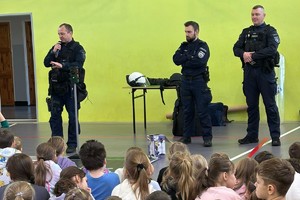 na zdjęciu umundurowani policjanci i uczestniczący w prelekcji dzieci