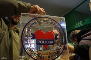 mężczyzna przekazuje pieniądze fundacji wspierającej rodziny poległych policjantów