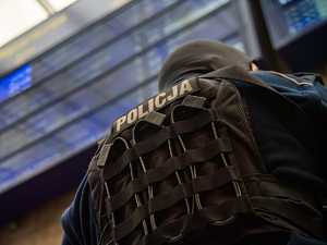 Policjant w kamizelce ochronnej na dworcu kolejowym