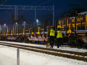 policjant oraz funkcjonariusz SOK i pies przy torach kolejowych