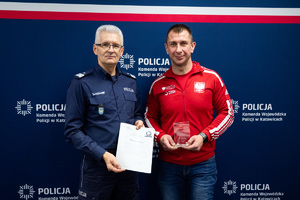 Komendant Wojewódzki Policji w Katowicach oraz uczestnik konferencji Policja dla dostępności - siła determinacji w drodze do sukcesu trzymający pamiątkowy upominek