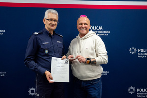 Komendant Wojewódzki Policji w Katowicach oraz uczestnik konferencji Policja dla dostępności - siła determinacji w drodze do sukcesu trzymający pamiątkowy upominek