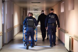 Policjanci wiozący wózkiem przez korytarz prezenty