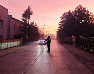 zdjęcie przedstawia policjanta zatrzymującego pojazd do kontroli