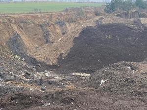 Świeży w dół w ziemi a w nim rozrzucone śmieci.