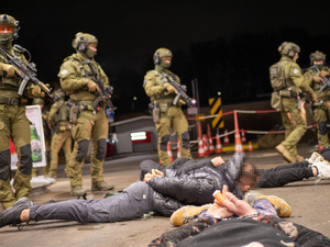 zdjęcie przedstawia funkcjonariuszy służb specjalnych oraz leżących na ziemi mężczyzn