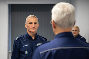 Wizerunek policjantów zwróconych do siebie twarzą.