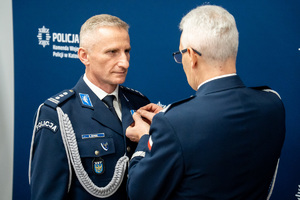 Na zdjęciu widoczny Pan Generał umieszczający medal na mundurze funkcjonariusza