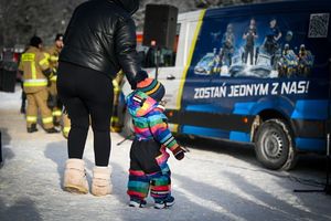 Na zdjęciu widoczne dziecko na tle policyjnego radiowozu