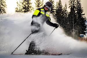 Zdjęcie przedstawia policjanta podczas zjazdu na nartach