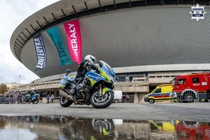 Policjanci na motocyklach oraz pojazdy innych służb na tle Hali Widowiskowej - Spodek.