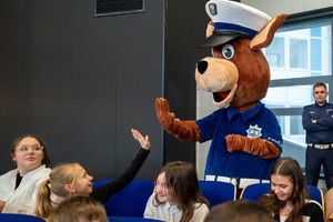 Na zdjęciu widoczna maskotka śląskiej drogówki, która przybija "piątkę" z dziewczynką.