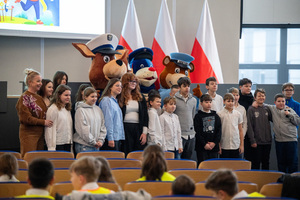 Zdjęcie grupowe, na którym widoczne są dzieci, kobieta oraz maskotki śląskiej Policji.