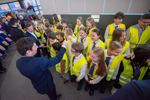 Na zdjęciu widoczni mężczyźni, którzy witają się z dziećmi. Dzieci mają założone kamizelki odblaskowe.