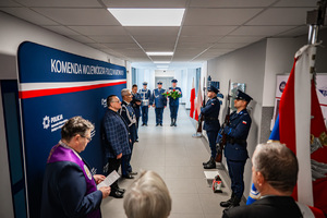 Grupa policjantów uczestnicząca w uroczystościach rocznicowych pod tablicą upamiętniającą postać insp. dr Adama Kocura