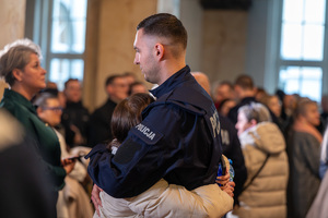 Na zdjęciu widoczny policjant, który przytula kobietę.