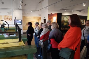 Grupa kobiet stoi przed przed maszyną.