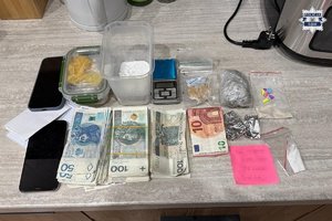 Na zdjęciu widać banknoty i różne substancje rozłożone na stole, a także wagę.