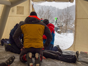Udzielanie pierwszej pomocy poszkodowanemu pod namiotem.