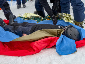 Zbliżenie na narciarza leżącego na śniegu.