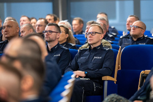 Kolorowe zdjęcie umundurowanych policjantów siedzących na widowni rotundy.