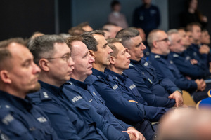 Kolorowe zdjęcie umundurowanych policjantów siedzących na widowni rotundy.