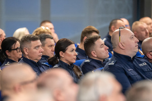 Kolorowe zdjęcie umundurowanych policjantów siedzących na widowni rotundy.
