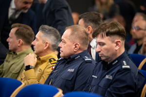 Kolorowe zdjęcie umundurowanych policjantów siedzących na widowni rotundy.
