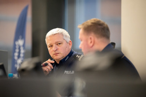 Kolorowe zdjęcie Zastępców Komendanta Wojewódzkiego w Katowicach siedzących za mównicą.