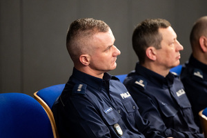 Kolorowe zdjęcie umundurowanych policjantów siedzących na widowni rotundy.