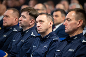 Kolorowe zdjęcie umundurowanych policjantów siedzących na widowni rotundy.