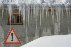 Grafika przedstawia wiszące sople lodu. W lewym dolnym roku biały trójkąt z czerwonym obramowaniem i czarnym wykrzyknikiem po środku.