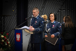Policjant z policjantką przy mównicy
